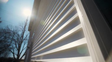 Güneşli bir günde modern panellerle Beyaz Kaplama ev duvarını geniş açıdan görmek, gösterişli ve klasik bir dış görünüş sağlıyor. Kamera görüntüsünü değiştir. Yüksek kalite 4k görüntü