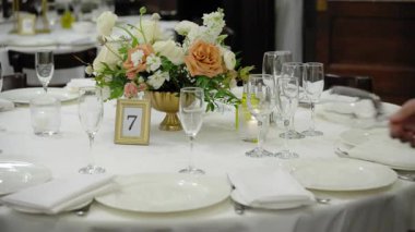 Kutlama partisi için bardaklı, tabaklı ve çatal bıçaklı masalar servis ediliyor. Düğün, doğum günü, kutlama partisi. Kamera yavaş çekim. Yüksek kalite 4k görüntü