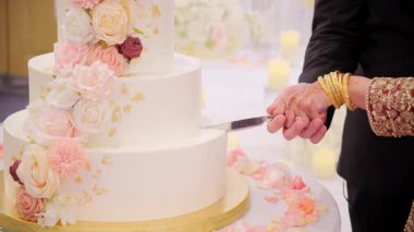 Hindistan 'daki düğün partisinde düğün pastası kesen bir gelin ve damat. Çekimi kapat. Yüksek kalite 4k görüntü