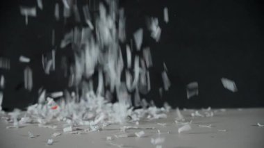 Parçalanmış ofis kağıtları masanın üstüne düşüp yığılıyor. Ağır çekim. Yüksek kalite 4k görüntü