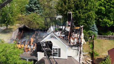 Yangından sonra yanmış bir ev ve itfaiyeciler yangına körükle gitmiş. Yukarıdan aşağıya insansız hava aracı görüntüleri. Yüksek kalite 4k görüntü