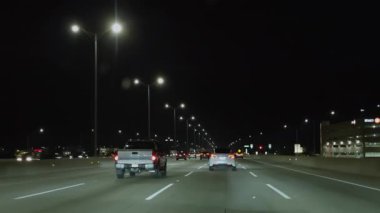 Gece vakti iyi aydınlatılmış otoyolda araba sürmek. İçerideki arabadan vurulmuş. Geniş bakış açısı. Yüksek kalite 4k görüntü
