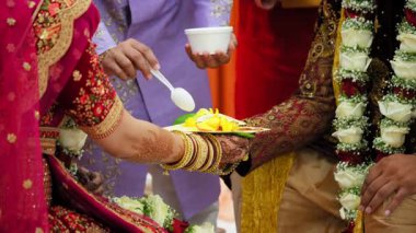  Kutsal düğün töreninde gerçekleştirilen Hint Hindu ayinleri. Gelin ve damat el ele tutuşuyorlar. Düğün töreninin bir kısmını yakından çek. Yüksek kalite 4k görüntü
