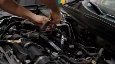 Tamircide arabanın kaputunun altında çalışan bir tamirci. Yüksek kalite 4k görüntü