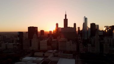 Gün batımında gökdelenlerin arkasında parlayan güneş ışığıyla Chicago 'nun gökyüzü manzarası. Yüksek kalite 4k görüntü