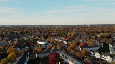 Sonbahar renklerinde ağaçlarla çevrili bir yerleşim yerinin panoramik drone görüntüsü. Yüksek kalite 4k görüntü