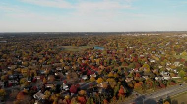 Sonbahar renklerinde ağaçlarla çevrili bir banliyö bölgesinin panoramik geniş hava görüntüsü. Yüksek kalite 4k görüntü