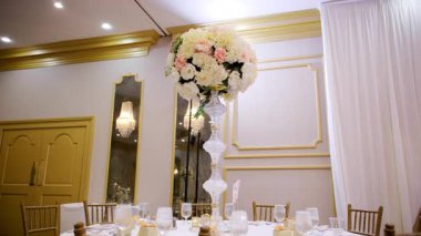 Restorandaki masanın üzerindeki süslü çiçek yerleştirme etkinliğin düğün süsü olarak. Kamera görüntüsünü değiştir. Yüksek kalite 4k görüntü