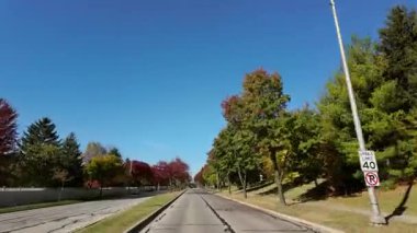 Güneşli bir sonbahar gününde, ABD 'nin banliyö sokağında. Hızlı giden arabadan geniş açılı görüntü. Yüksek kalite 4k görüntü