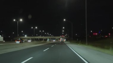 Gece vakti iyi aydınlatılmış otoyolda araba sürmek. FedEx 'i kovalıyorum. Geniş bakış açısı. Naperville lL 'de. ABD 2 Mart 2025. Yüksek kalite 4k görüntü