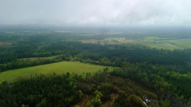 Kır Tarlaları 'nın geniş insansız hava aracı görüntüsü ve Bulutlarla kaplı Orman yakınlarında bir çiftlik. Yüksek kalite 4k görüntü