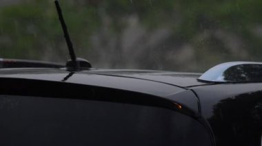 Şiddetli yağmur. Park yerindeki siyah arabanın üzerine yağmur damlaları düşer. - Evet. Yüksek kalite 4k görüntü