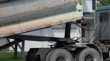 Harap olmuş yol yüzeyinden çıkarılan eski asfaltla dolu çöp kamyonunun arka tekerlekleri yerine yeni bir yüzey, eski asfaltı parçalayıcı taşır. Yüksek kalite 4k görüntü