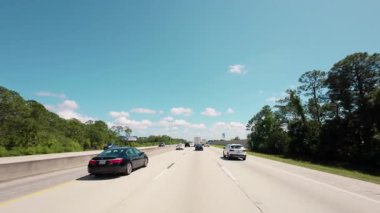 Açık mavi gökyüzü ufku olan bir otoyolda araba ve Home Depot kamyonundan POV görüntüsü. Miami FL 'de. ABD 2 Nisan 2025. Yüksek kalite 4k görüntü