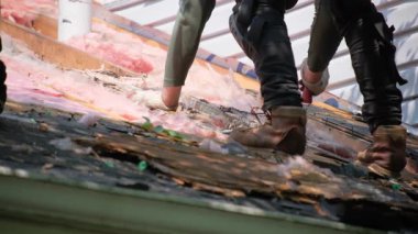 Çatı ustası hasarlı çatının eski ahşap döşemesini kaldırır. Sonra da eve yeni bir örtü yerleştirir. Kapatın. Yüksek kalite 4k görüntü
