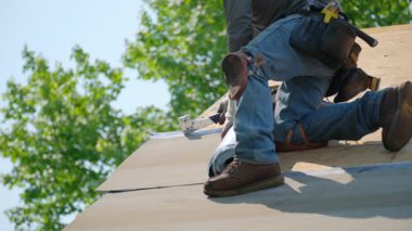 Roofer yapıştırıcı yüzeyi ile kaplı yeni bir çatı kuruyor. Yeni bir çatı kurulum süreci. Yüksek kalite 4k görüntü