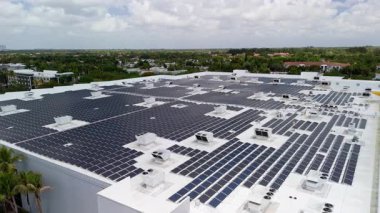 Ticari alışveriş merkezinin çatısına yeşil ekolojik elektrik üretmek için kurulmuş güneş enerjisi santrali panellerinin geniş hava görüntüleri. Yüksek kalite 4k görüntü
