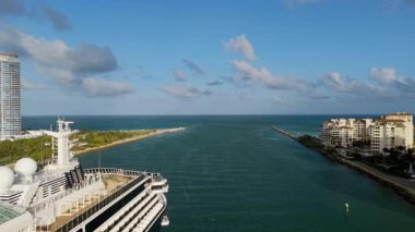 Büyük yolcu gemisi güneşli bir günde Miami limanından ayrılıyor. Geniş hava manzaralı. Manzarayı kapat. Yüksek kalite 4k görüntü