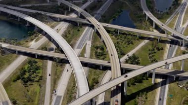 Miami 'de yükseltilmiş bir otoyol kavşağı, hareket halindeki araçlarla dolu, bulutlu bir gökyüzü altında ABD ulaşım altyapısını sergiliyor. Manzarayı kapat. Yüksek kalite 4k görüntü