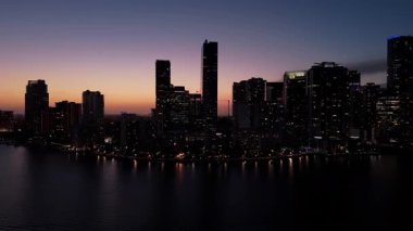 Alacakaranlıkta Miami sahilindeki modern gökdelenler renkli Sunset Light tarafından aydınlatılıyor. Geniş görüş. Yüksek kalite 4k görüntü