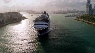 Büyük yolcu gemisi güneşli bir akşamda Miami limanından ayrılıyor. Geniş hava manzaralı. Yüksek kalite 4k görüntü