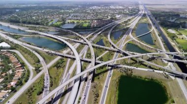 Miami 'de yükseltilmiş bir otoyol kavşağı, hızlı hareket eden araçlar, bulutlu bir gökyüzü altında ABD ulaşım altyapısını sergiliyor. Manzarayı kapat. Yüksek kalite 4k görüntü