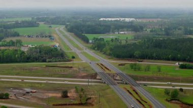 Otoyol boyunca kavşakları ve güzel yeşil banliyöleri olan insansız hava aracı manzarası. Geniş hava aracı görüşü. - Evet. Yüksek kalite 4k görüntü