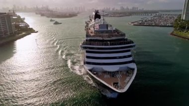 Büyük yolcu gemisi güneşli bir akşamda Miami limanından ayrılıyor. Geniş hava manzaralı. Manzarayı kapat. Yüksek kalite 4k görüntü