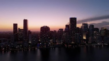 Miami sahilindeki modern gökdelenler Sunset Light tarafından aydınlatılmış alacakaranlıkta. Yüksek kalite 4k görüntü