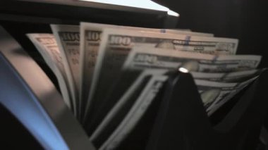 Para sayma makinesinin görüntüsünü kapat. 100 dolarlık banknotları olan bir tezgah makinesi. Ağır çekim. Yüksek kalite 4k görüntü