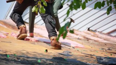 Roofer hasarlı çatının eski ahşap döşemesini kaldırır. Sonra da eve yeni bir örtü yerleştirir. İş unsurları. Yüksek kalite 4k görüntü