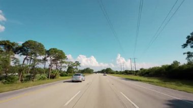 Açık mavi gökyüzü ufkuyla kırsal bir yolda araba sürerken POV görüntüsü. Yüksek kalite 4k görüntü