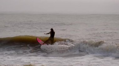Genç sörfçü, Jacksonville, Florida 'da güneşli bir günde dalgalara binmeye çalıştığında düşer. Jacksonville FL 'de. ABD 2 Nisan 2025. Yüksek kalite 4k görüntü