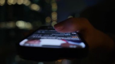 Akşamları Balkon 'da telefondan kayan akıllı telefonu kullanan kadın. Telefon Mockup ile Balkondan Şehir Manzarası. Yüksek kalite 4k görüntü