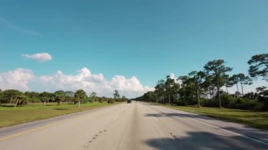 Açık mavi gökyüzü ufkuyla kırsal bir yolda araba sürerken görüntüsü. Yüksek kalite 4k görüntü