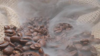 Dumanlı kavrulmuş kahve çekirdekleri. Duman taze kahve çekirdeklerinden geliyor. Yüksek kalite 4k görüntü
