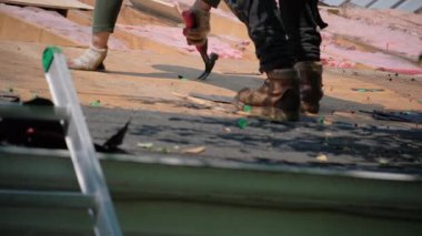 Roofer, bir eve yeni bir örtü takmadan önce hasarlı çatı kaplamasının eski tırnağını söker. İş unsurları. Yüksek kalite 4k görüntü