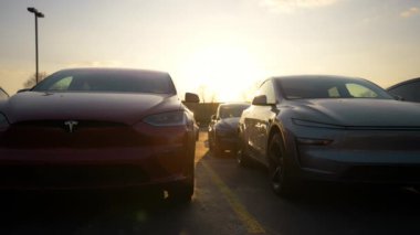 Gün batımında, bir araba galerisinin otoparkındaki sıra sıra Tesla arabalarını seyret. Naperville lL 'de. ABD 2 Nisan 2025. Yüksek kalite 4k görüntü