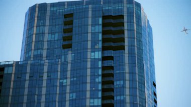 Şikago şehir merkezindeki gökdelenin durağan görüntüsü. Gündüz vakti camlarında uçak yansıması, modern mimarinin altını çiziyor. Yüksek kalite 4k görüntü