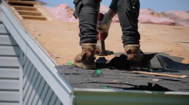 Roofer, bir eve yeni bir örtü takmadan önce hasarlı çatı kaplamasının eski tırnaklarını söker. İş unsurları. Yüksek kalite 4k görüntü
