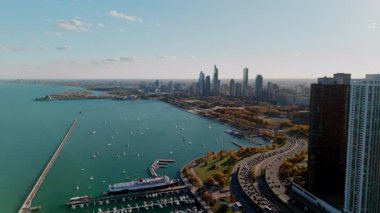 Gün batımında gökdelenlerin arkasında parlayan altın güneş ışığıyla Chicago 'nun gökyüzü insansız hava aracı görüntüsü. Michigan Gölü manzaralı. Yüksek kalite 4k görüntü