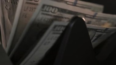 Para sayma makinesinin yakın görüntüsü. Sayaç makinesi 100 dolarlık banknotları hesaplıyor. Ağır çekim. Yüksek kalite 4k görüntü