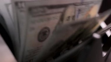Para sayma makinesinin yakın çekim görüntüsü. Sayaç makinesi 100 dolarlık banknotları hesaplıyor. Ağır çekim. Yüksek kalite 4k görüntü