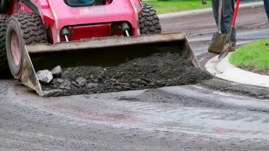  Kompakt yükleyici, kaldırım ya da yol onarım projesi sırasında asfalt ya da toprak toplayan ön kovayla kayma dümeni. Yüksek kalite 4k görüntü