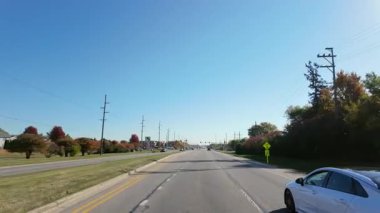 Amerika 'nın banliyölerindeki banliyö otoyolu güzel, güneşli bir sonbahar gününde. Hızlı giden arabadan geniş görüş açısı. Naperville lL 'de. ABD 20 sep 2024. Yüksek kalite 4k görüntü