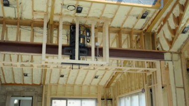 Fiberglas yalıtım malzemesi evin bodrumundaki ahşap duvarlar arasına ya da inşaat alanına monte edilmiş. Manzarayı kapat. Yüksek kalite 4k görüntü