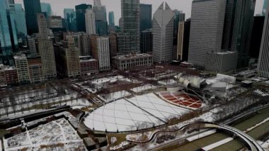 Chicago şehir merkezindeki karlı şehir manzarası. Millennium konser salonu ve yaya köprüsü olan yüksek binalar. - Evet. Yüksek kalite 4k görüntü