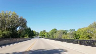 Hareket halindeki bir araçtan geniş çaplı görüntüler alındı. Parlak ve güneşli bir sabah ABD 'de bir yerleşim yerini ve parkı ele geçirildi. Yüksek kalite 4k görüntü