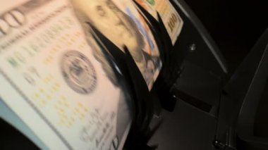 Para sayma makinesinin yakın görüntüsü. Sayaç makinesi 100 dolarlık banknotları hesaplıyor. Ağır çekim. Yüksek kalite 4k görüntü