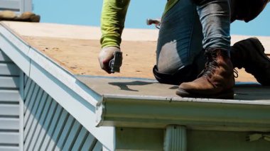 Roofer yeni çatı kaplaması için çekiç kullanıyor. Bir eve yeni bir çatı kurmak. İş unsurları. Yüksek kalite 4k görüntü